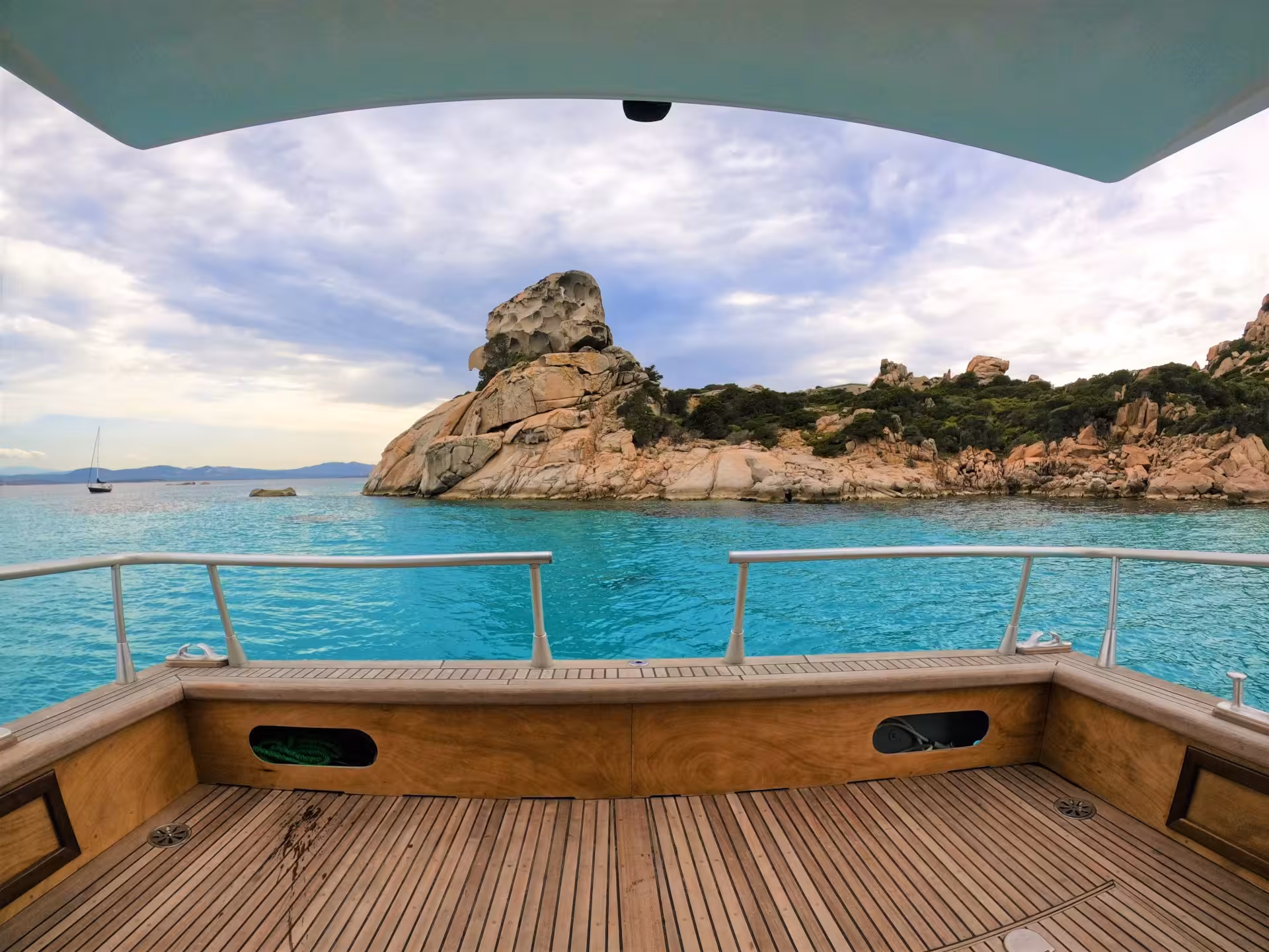 Experience breathtaking coastal scenery from a boat deck in La Maddalena Archipelago's turquoise waters.