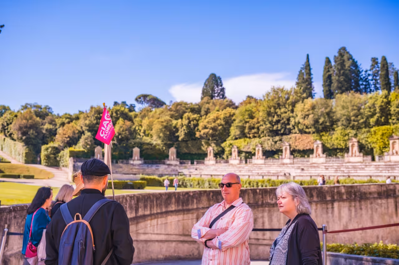 Small group tour exploring the Boboli Gardens' lush greenery in Florence under a clear blue sky.