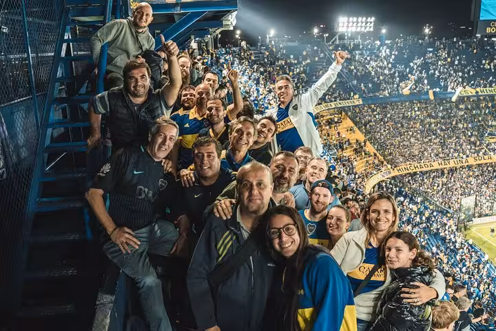 Group cheering inside La Bombonera during Boca Juniors game, stadium seats view on local matchday tour with transport