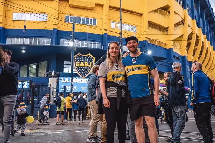 Couple outside La Bombonera before Boca Juniors match, guided local tour with round-trip transport in Buenos Aires