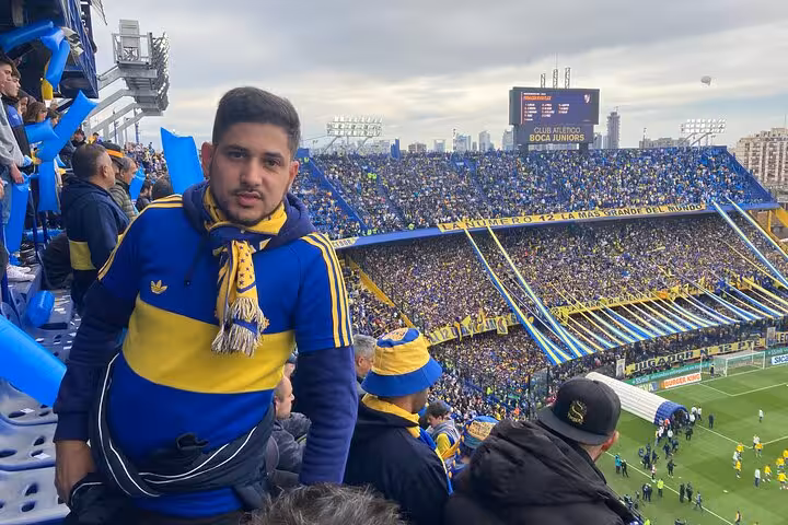 Boca Juniors supporter in the stands at La Bombonera, matchday experience with local host and transport