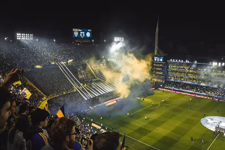 Night match at La Bombonera with Boca Juniors crowd, flags and smoke show, guided tour with transport