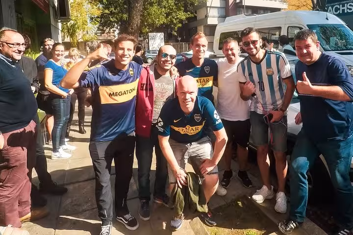 Travelers pose in Boca Juniors shirts on a La Boca walking tour in Buenos Aires with a local guide