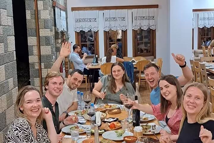 Group enjoying a vibrant dinner with wine tasting at a cozy restaurant during Bogove's Splendor adventure tour.