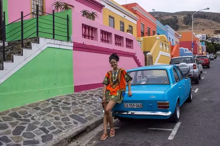 Colorful Bo-Kaap street with vibrant houses and a vintage car, Cape Town sightseeing on Cape Point tour.