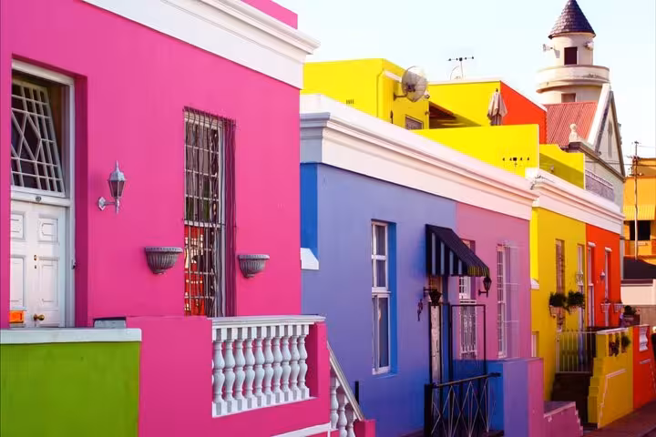 Brightly painted Bo-Kaap houses in Cape Town, featuring a mix of pink, yellow, and blue facades.
