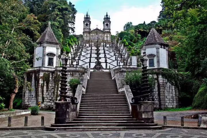 Panoramic view of Bom Jesus do Monte's grand staircase in Braga surrounded by lush greenery and ornate sculptures.