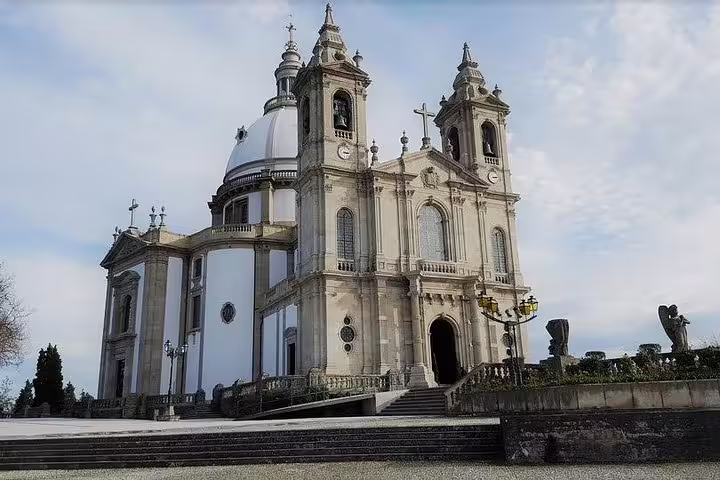 Majestic facade of the Bom Jesus do Monte Sanctuary in Braga under a cloudy sky, showcasing its architectural grandeur.