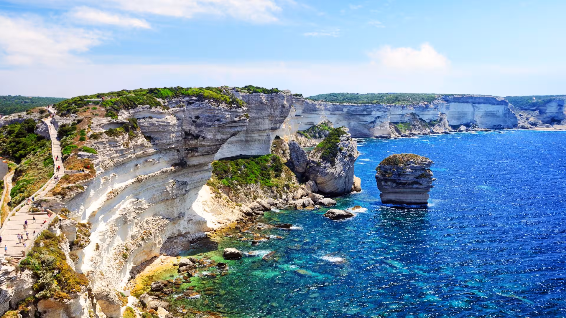 Stunning view of Bonifacio's dramatic white cliffs and turquoise sea on a Corsica wooden boat tour.