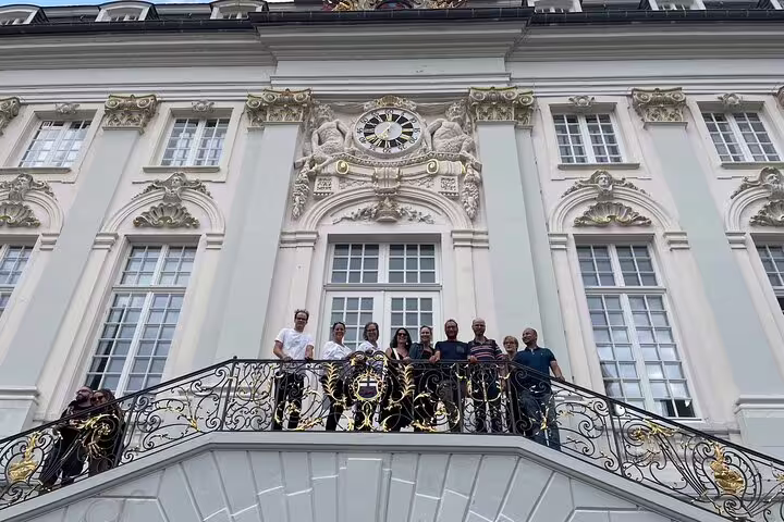 Group on Bonn City Hall staircase during self-guided scavenger hunt tour, exploring landmarks in Bonn Altstadt