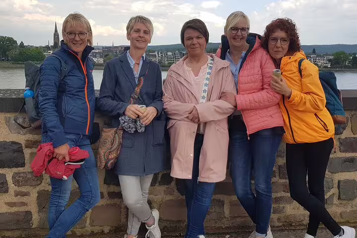 Group photo on Bonn riverside promenade with Rhine views, enjoying a self-guided Bonn scavenger hunt tour