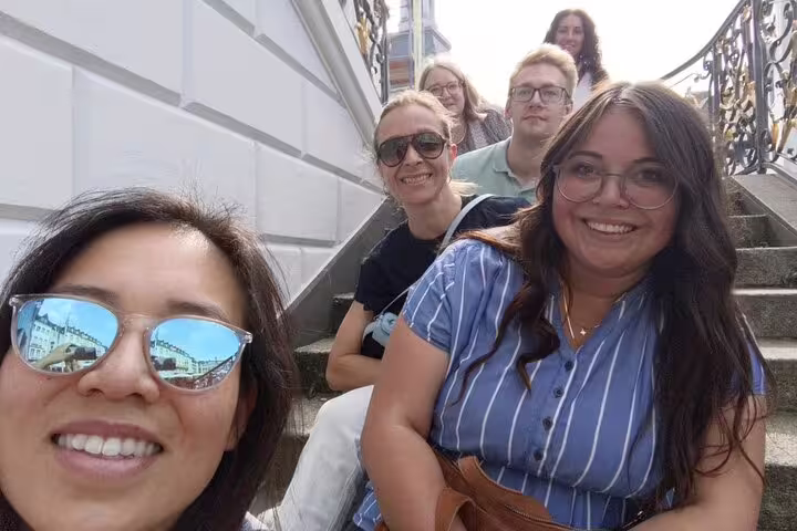 Friends smiling on Bonn city steps during a self-guided scavenger hunt sightseeing walking tour