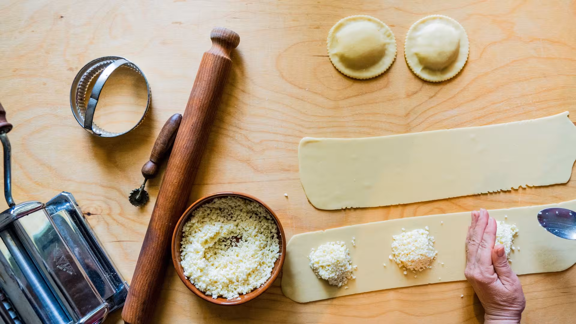 Crafting seadas with fresh cheese and traditional tools on a wooden surface at Bonorva's Sardinian workshop.