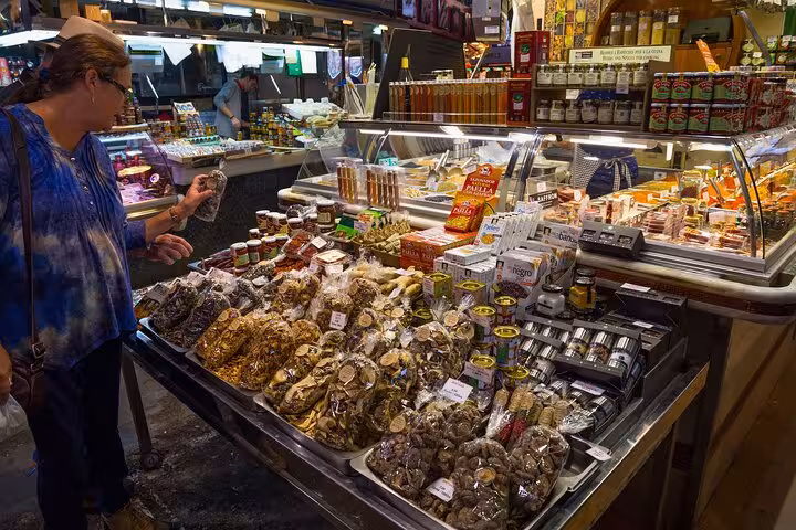 Traveler browsing gourmet olives and Catalan delicacies at La Boqueria on a Barcelona local markets food tour