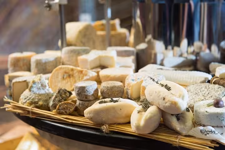 A selection of artisanal French cheeses displayed on a wooden board during a Bordeaux walking food tour.