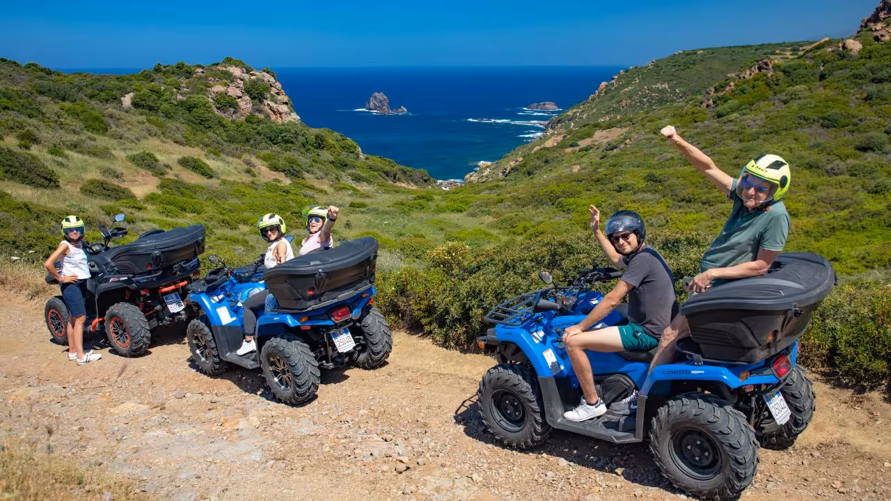 Excited participants on Bosa ATV tour pause for a scenic view of the ocean and green hills.