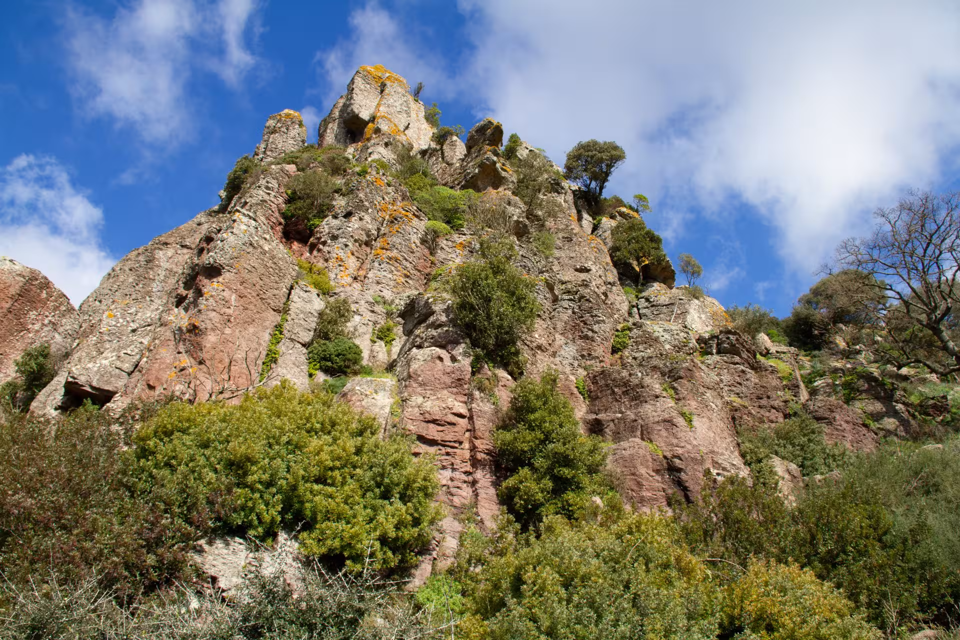 Rugged rock formations and lush greenery under a bright blue sky, typical scenery on the Bosa 3-hour ATV adventure.