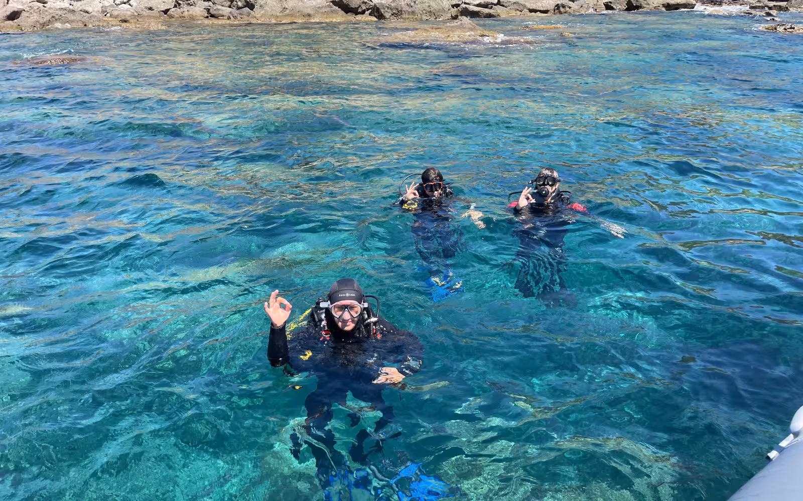 Group of divers enjoying Bosa's vibrant underwater world, ideal for a thrilling diving baptism adventure.