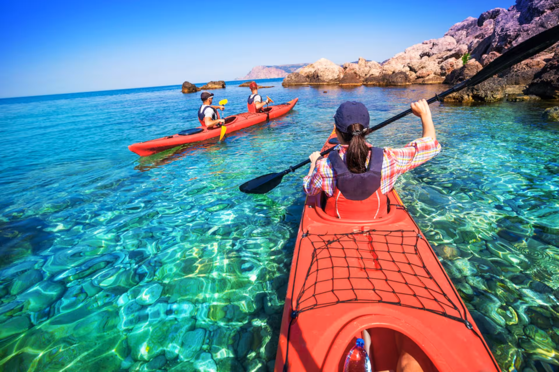 Kayakers paddle through crystal-clear waters on the Temo River, enjoying a scenic Bosa kayak rental adventure.