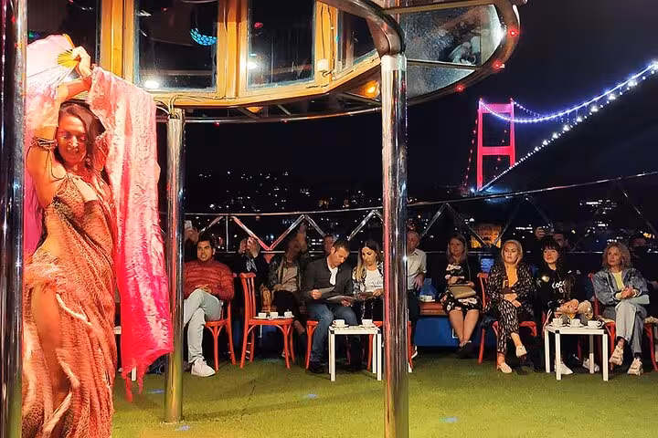Bosphorus dinner cruise private table with belly dance show and illuminated Bosphorus Bridge at night