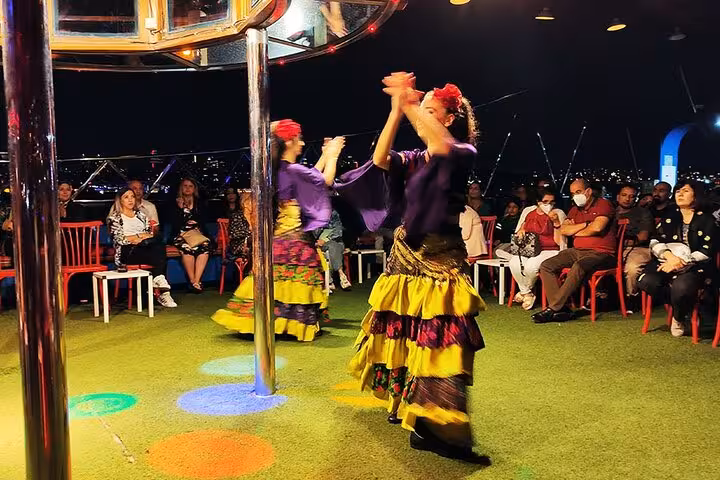 Colorful dancers performing on Bosphorus dinner cruise with private table, night views and onboard show