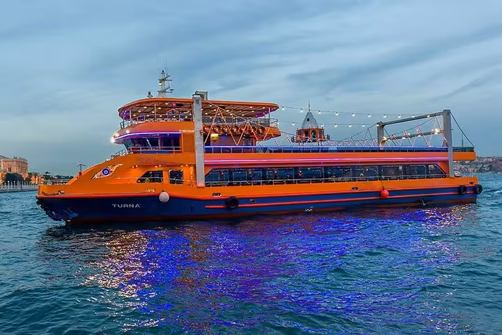 Istanbul Bosphorus dinner cruise boat at dusk with illuminated decks, ideal for private table dining experience