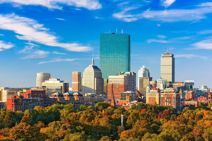 Boston skyline with fall foliage and Back Bay skyscrapers under blue sky