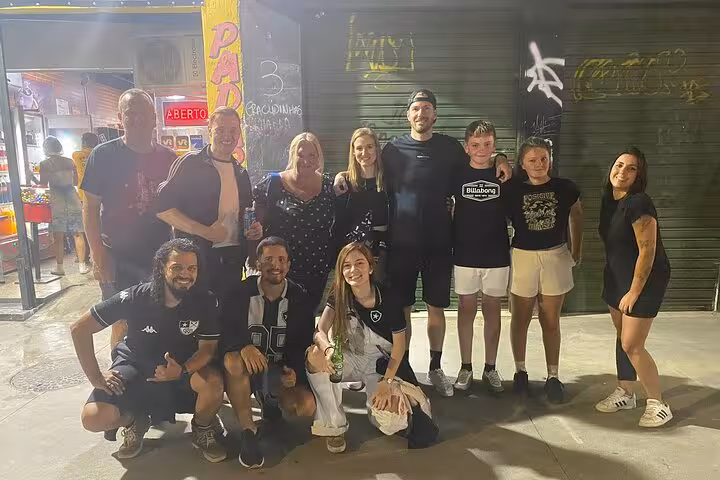 Group of travelers with locals in Botafogo jerseys gathering in Rio before the soccer game and fan tour