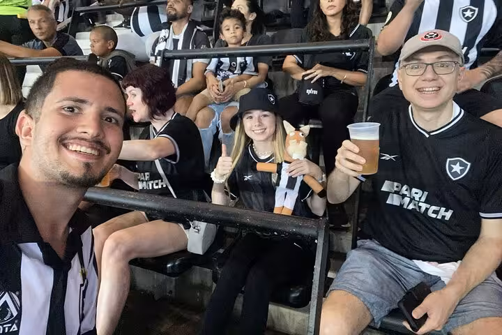 Fans with local guide in Botafogo shirts enjoy beers and cheer from the stands on Rio de Janeiro matchday tour