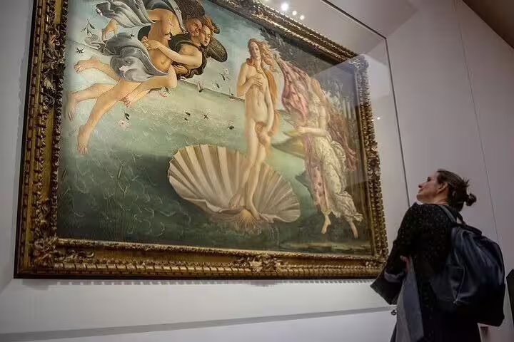 Tourist admires Botticelli’s Birth of Venus during a skip-the-line Uffizi Gallery guided visit on the Florence combo tour