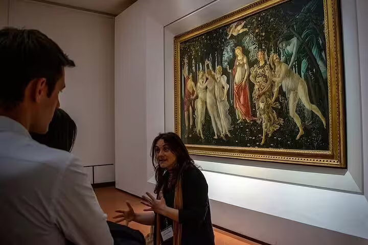 Expert guide explains Botticelli masterpieces to a small group inside the Uffizi Gallery on a skip-the-line Florence tour