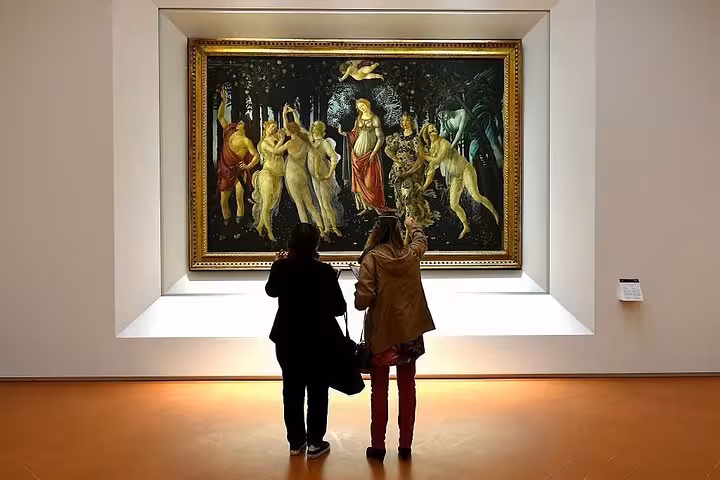Visitors admire Botticelli's 'Primavera' in the Uffizi Gallery, a highlight of the Accademia & Uffizi private tour.