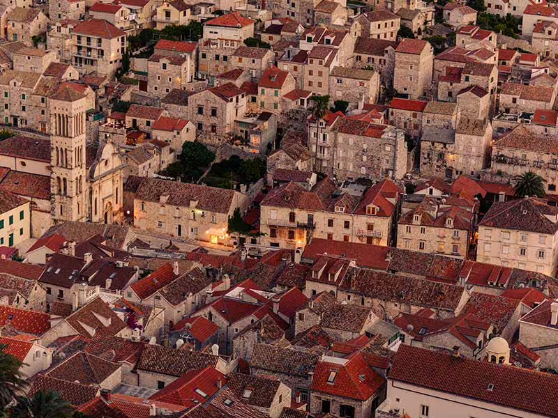 Aerial view of Brac Island stone village with red rooftops at sunset, scenic stop on private boat tour