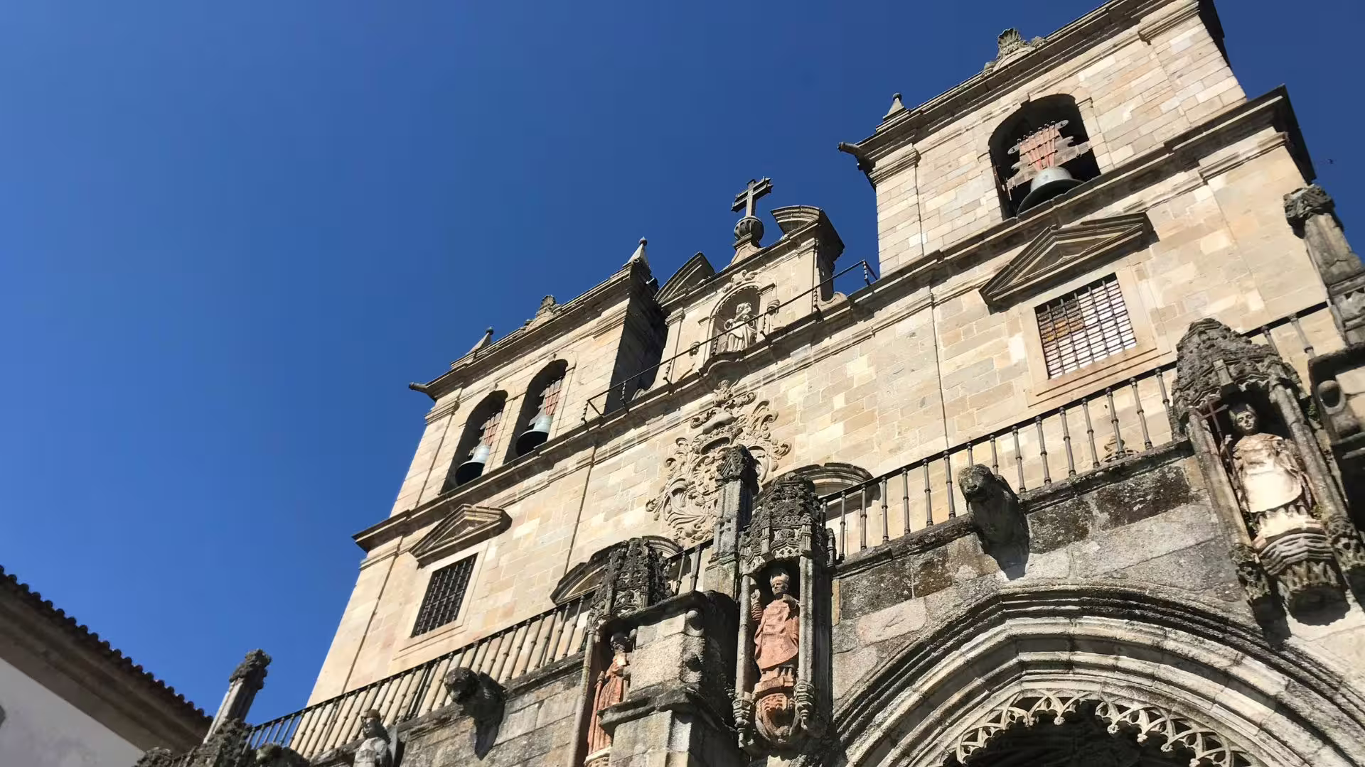 Close-up of Braga Cathedral's ornate facade against a clear blue sky, highlighting its historical significance.