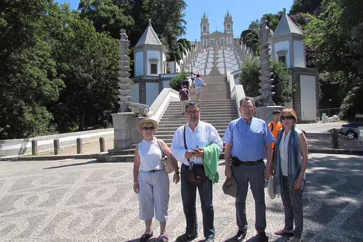 Tourists posing at the iconic staircase of Bom Jesus do Monte during Braga and Guimarães tour from Porto.