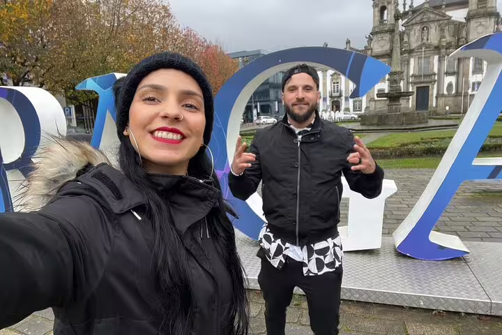 Travelers pose by Braga letters on a self-guided scavenger hunt walking tour near the city’s cathedral