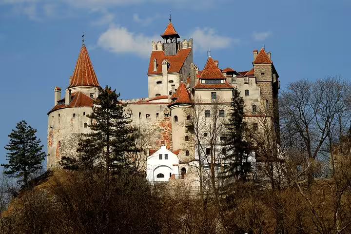Bran Castle perched on a hilltop in Transylvania, Romania, featuring medieval towers and red-tiled roofs