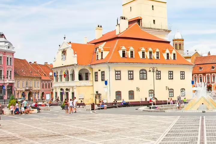 Brasov Council Square with historic buildings and orange rooftops on a sunny day