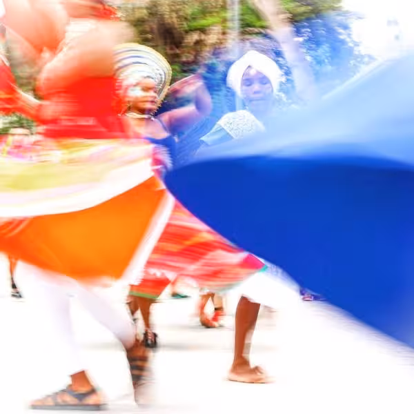 Dancers in colorful traditional attire twirling energetically at a Brazilian carnival street festival.