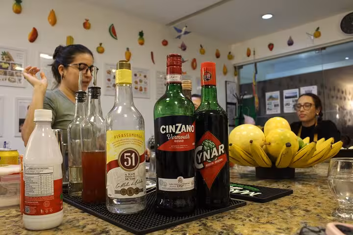Variety of spirits and mixers on a countertop during a Brazilian cocktail class, highlighting authentic ingredients.