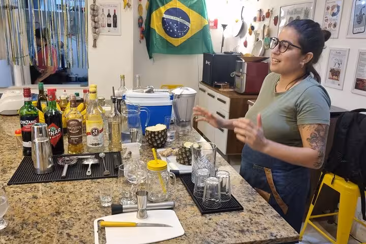 A mixologist passionately explains Brazilian cocktail making with a variety of spirits and tools in a vibrant setting.