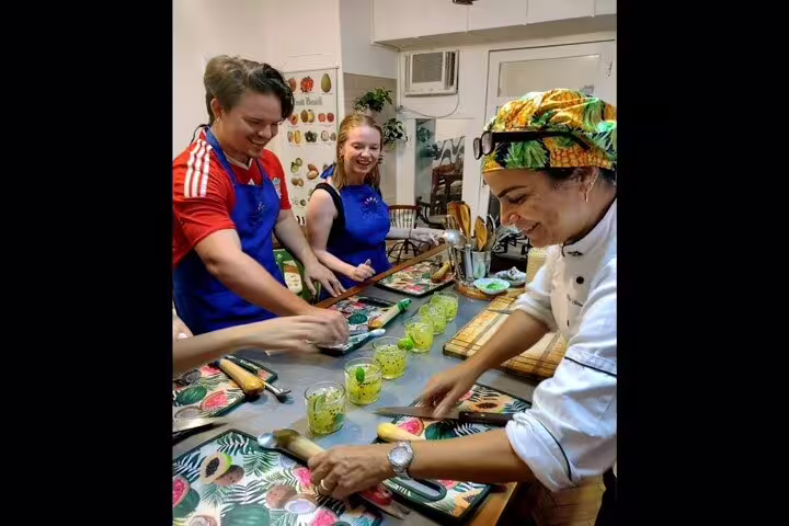 Chef guiding participants in hands-on Brazilian cooking class with fresh ingredients in Rio de Janeiro.