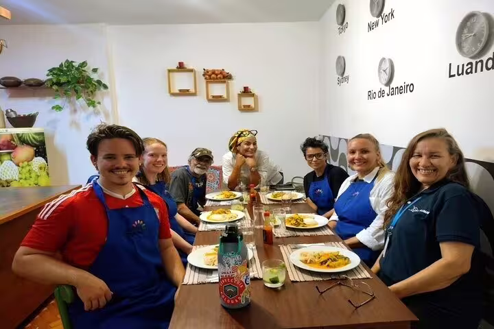 Participants enjoy a meal together at a Brazilian cooking class in Rio de Janeiro, showcasing traditional dishes.