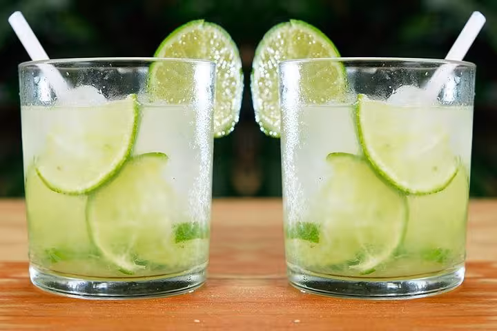Refreshing caipirinhas with lime slices served at a traditional Brazilian diner with live music.