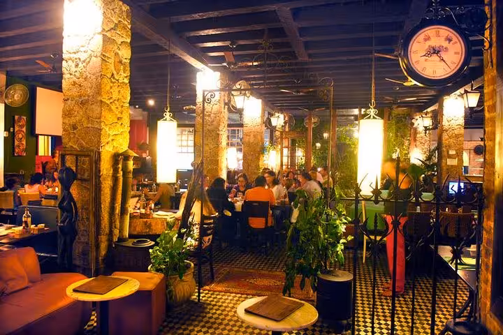 Cozy Brazilian diner with lush greenery and ambient lighting, offering an inviting atmosphere for dining and live music.