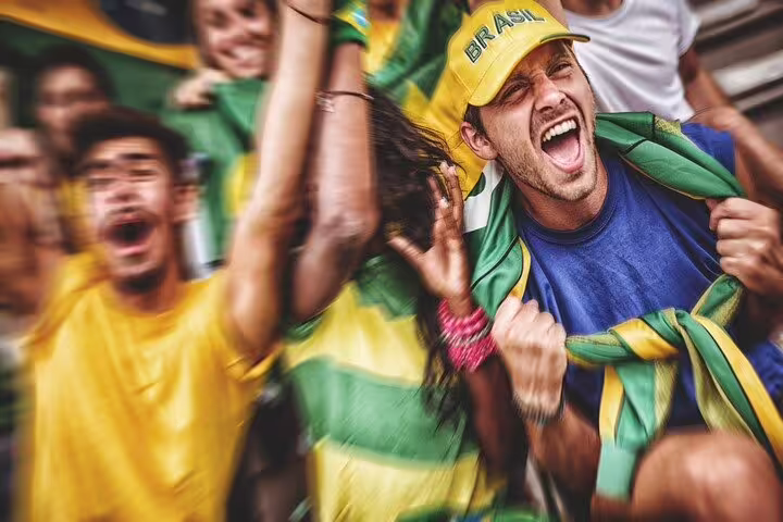 Enthusiastic fans in Brazilian colors cheer passionately at São Paulo's stadium football match.