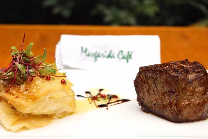 Gourmet Brazilian steak and layered potato dish at a traditional diner with live music.