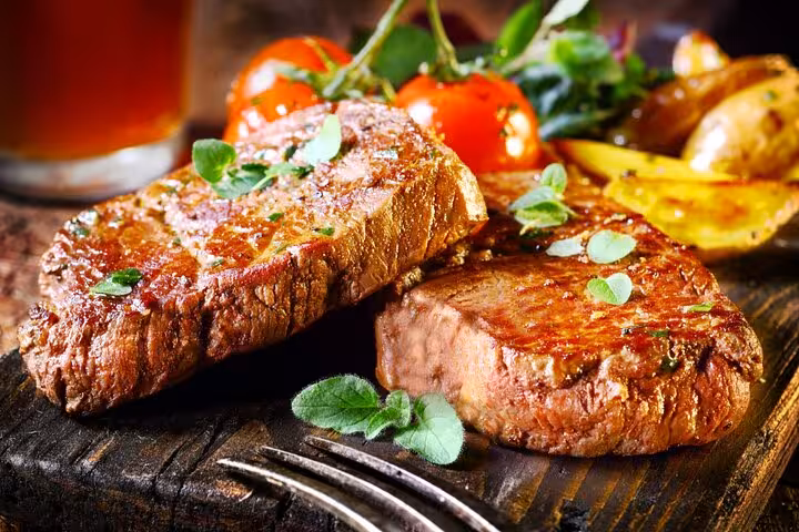 Juicy Brazilian steaks garnished with herbs, served with roasted vegetables for an authentic culinary experience.