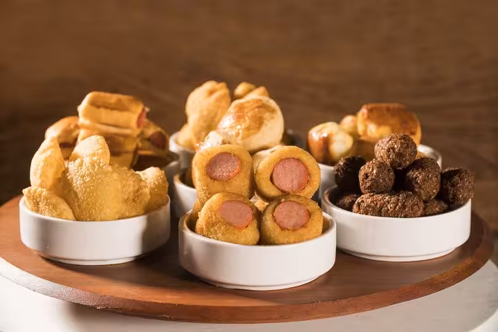 Assorted Brazilian street snacks including coxinhas and kibbeh, displayed in bowls for a rich culinary experience.