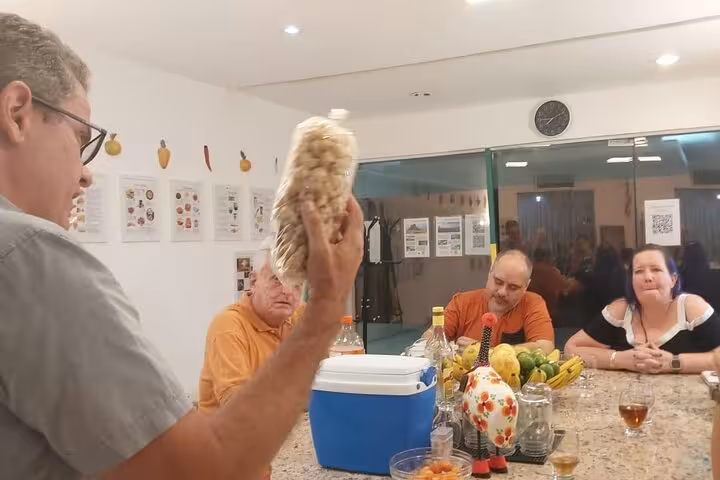 A lively gathering with a presenter showcasing Brazilian snacks, perfect for culinary enthusiasts exploring new flavors.